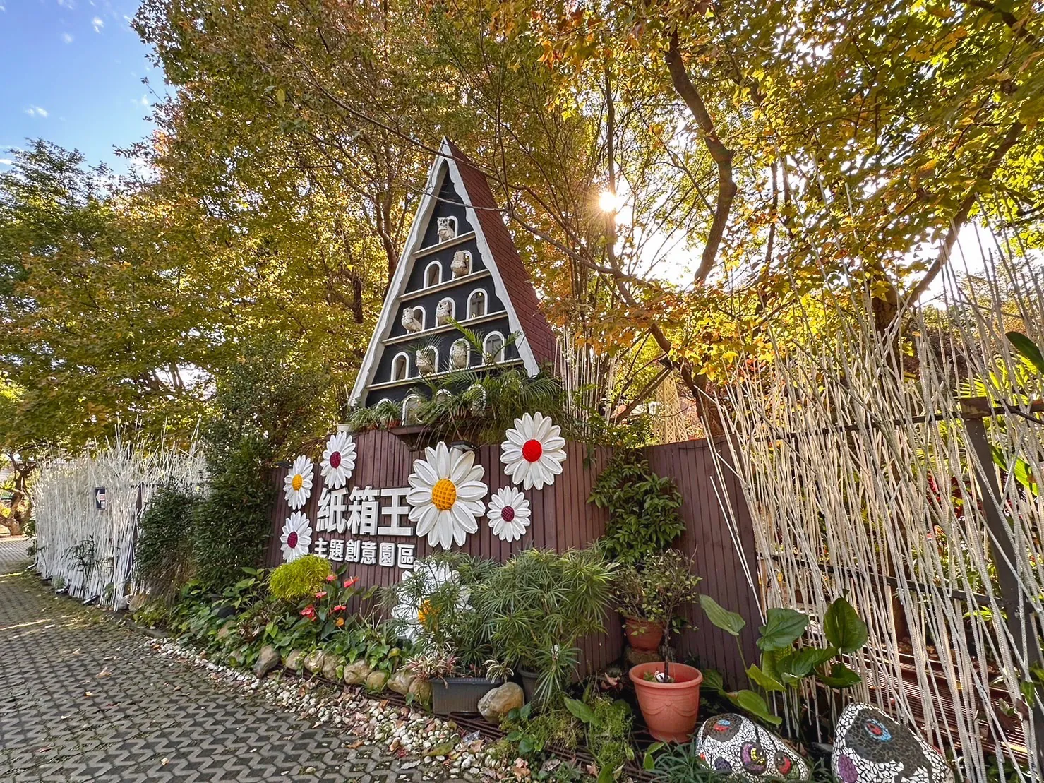 紙箱王創意園區大坑店入口的三角屋造型招牌與雛菊裝飾